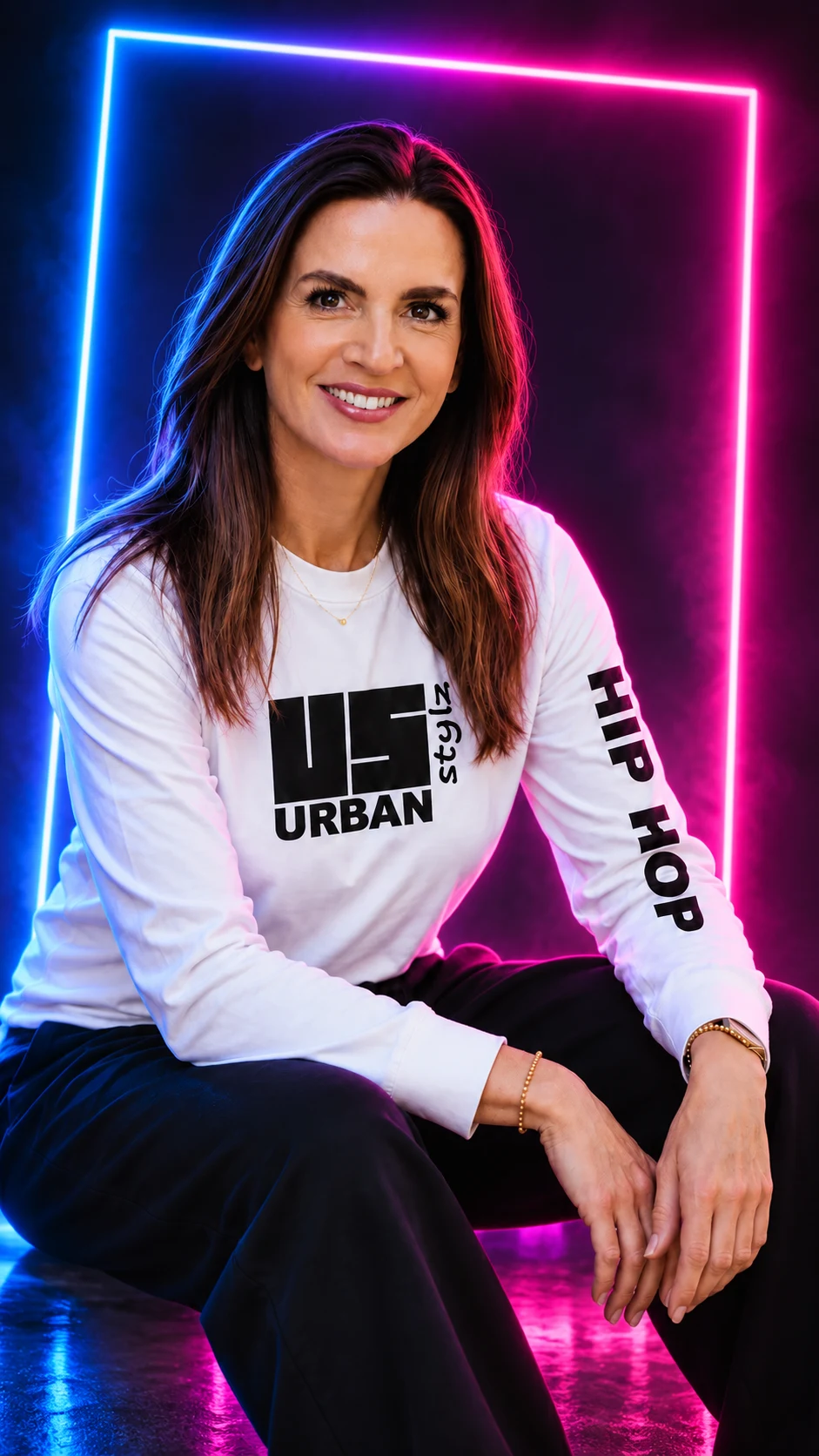 Hanneke Hinze in een wit UrbanStylz-shirt, lachend voor een neonkader